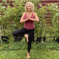 Mary Butler Fink in front of shrub doing a yoga pose