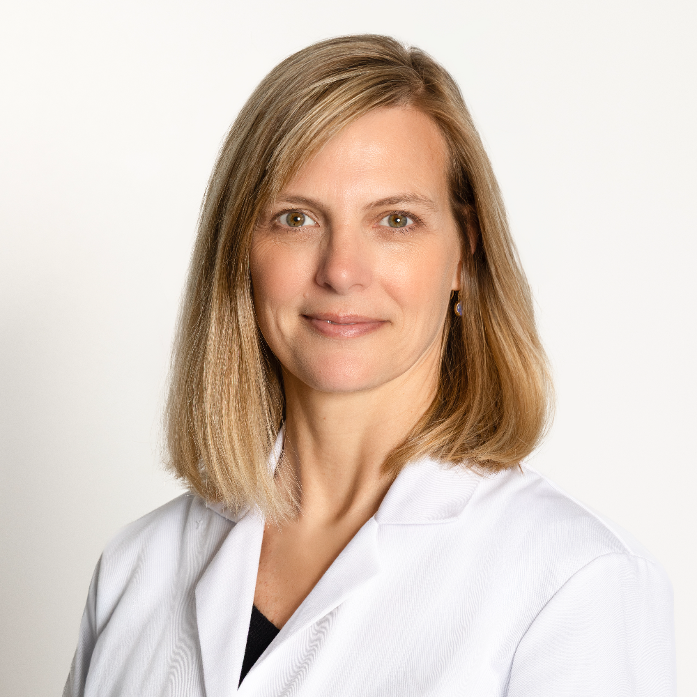 woman with blond hair wearing a white coat