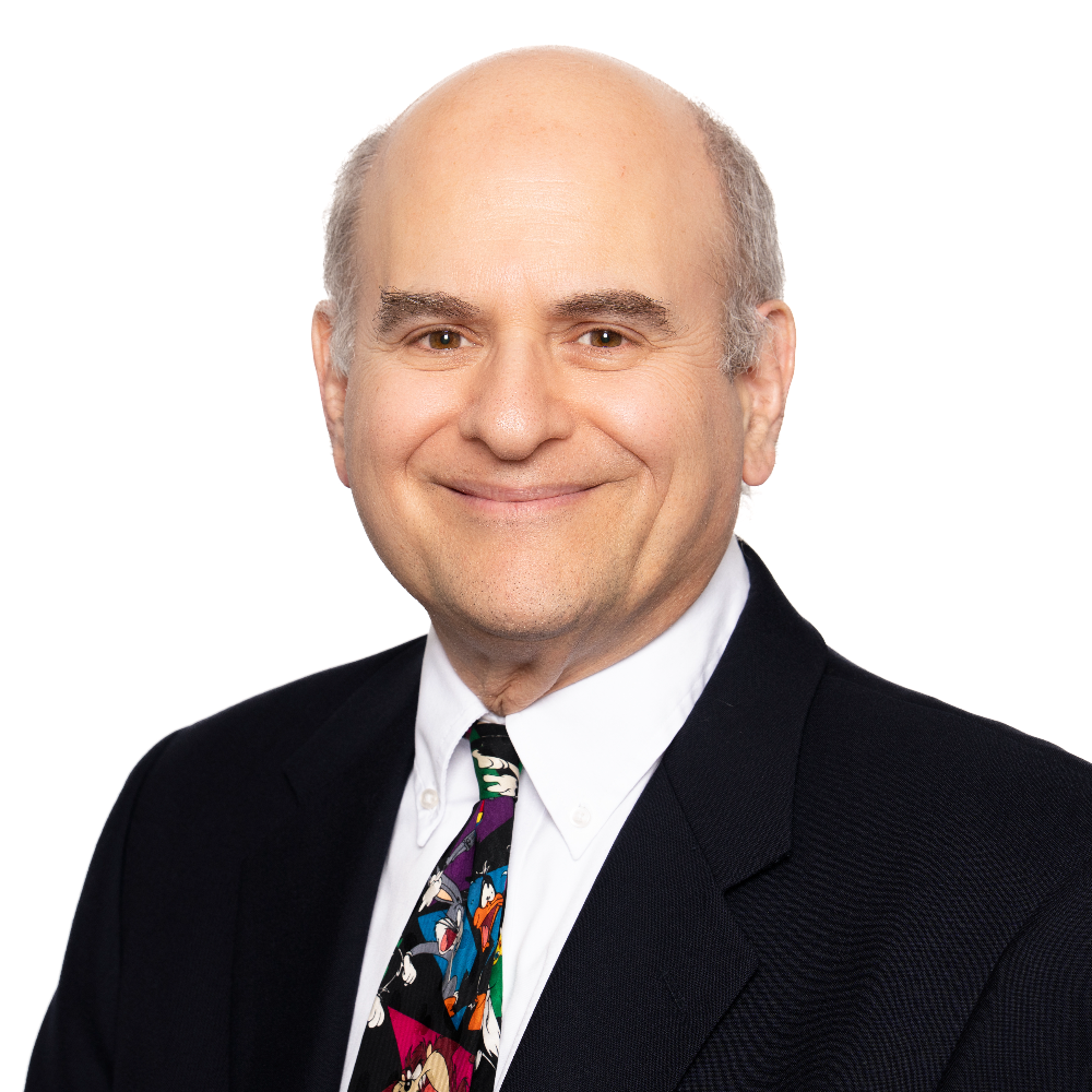 man with dark suit and loony tunes tie