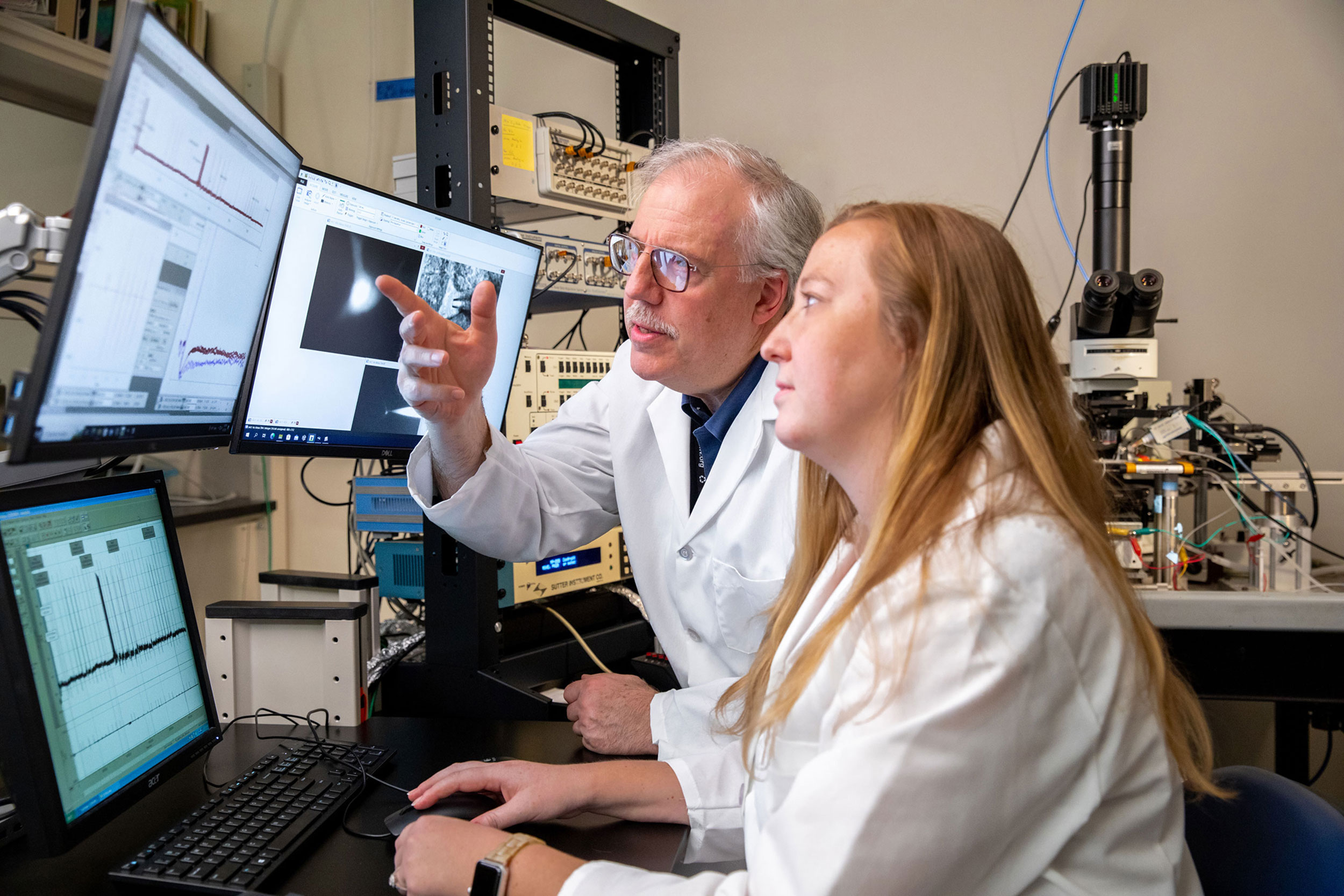 Student and professor looking at data together on computer screen