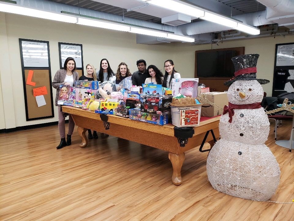 Group of people standing around a table beside an artificial snowman