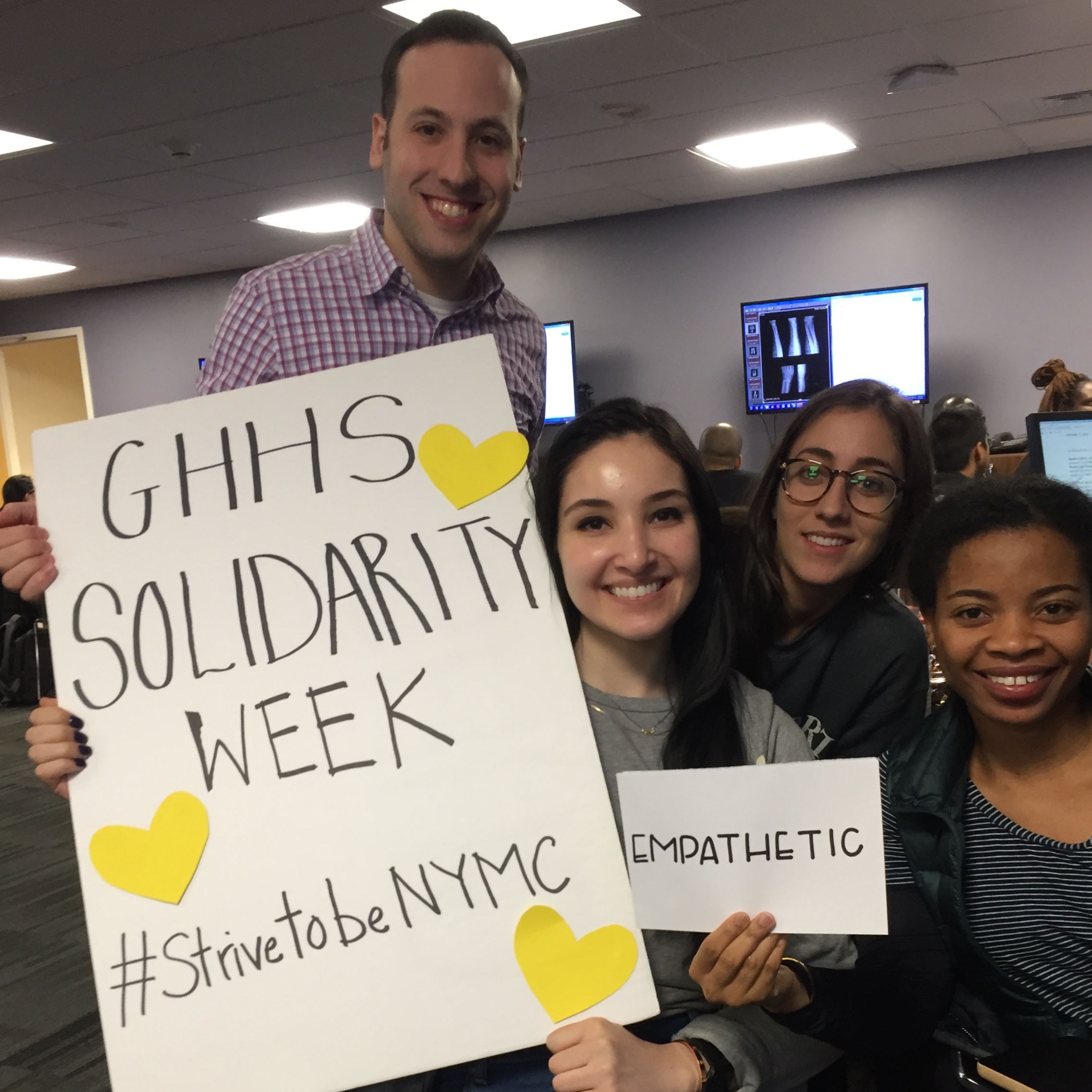 GHHS Solidarity Week Group Photo where three individuals hold cards. Each card displays words such as kindness, empathy, etc 