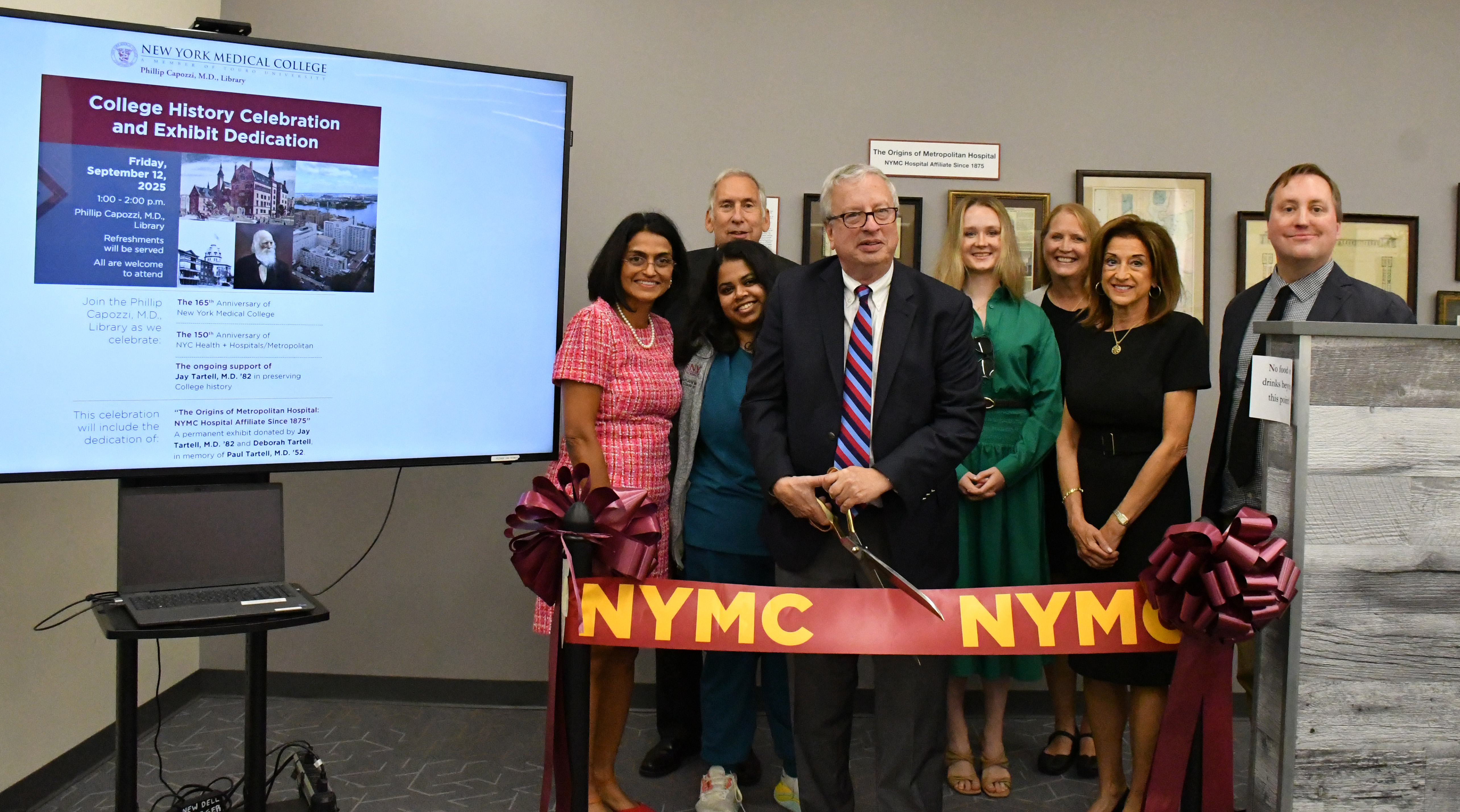 People gathered around a ribbon cutting inside of a building
