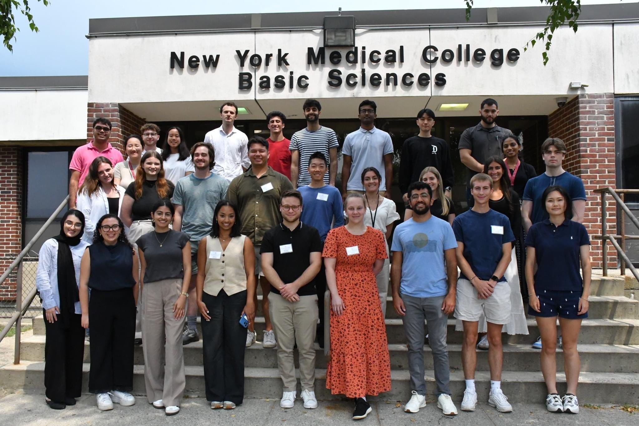 Students wearing casual clothing outside the Basic Sciences Building steps.