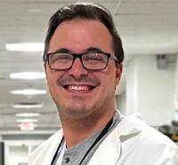 Medical student with glasses wearing a white coat