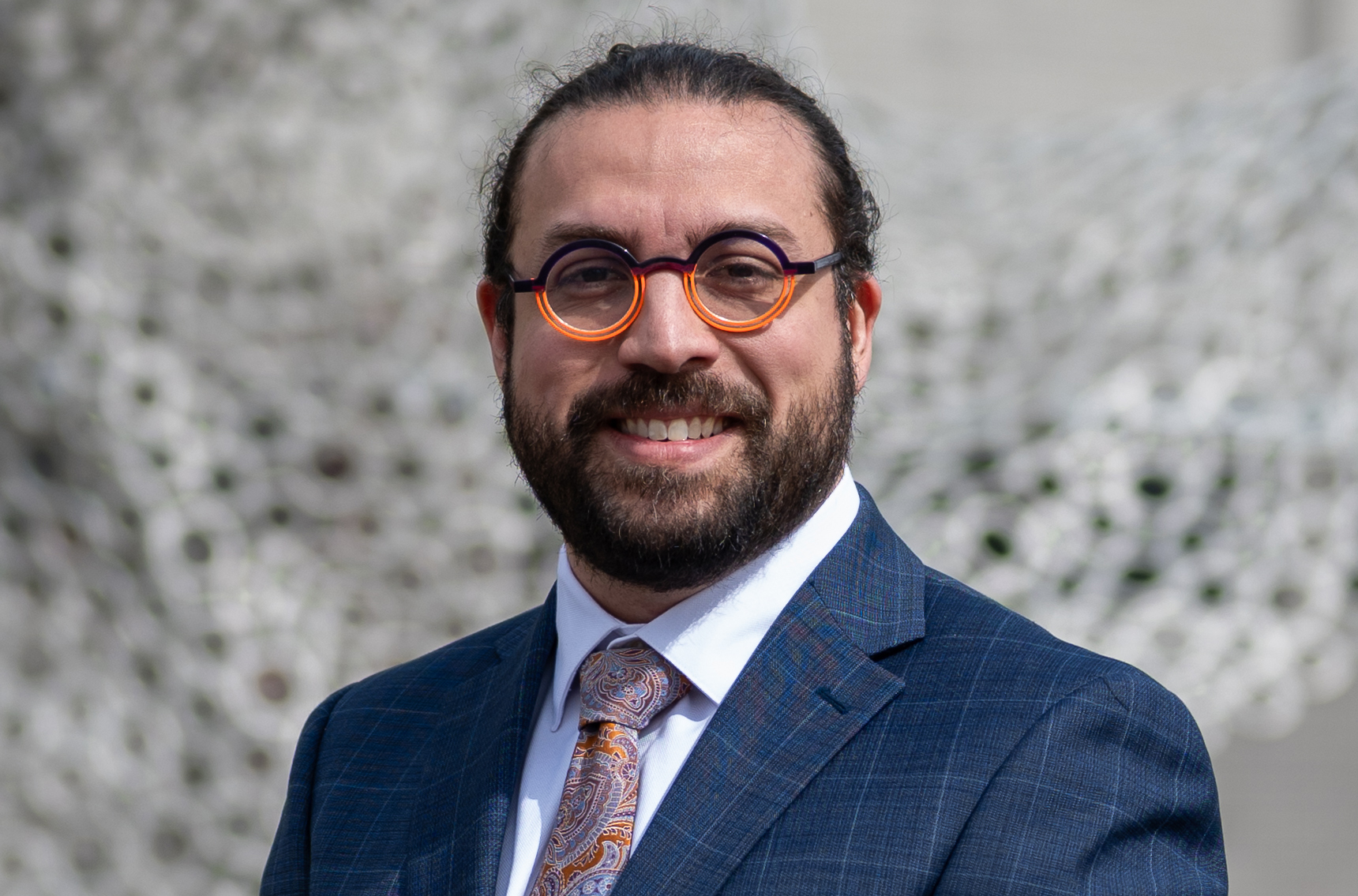 Man with glasses wearing a suit and tie