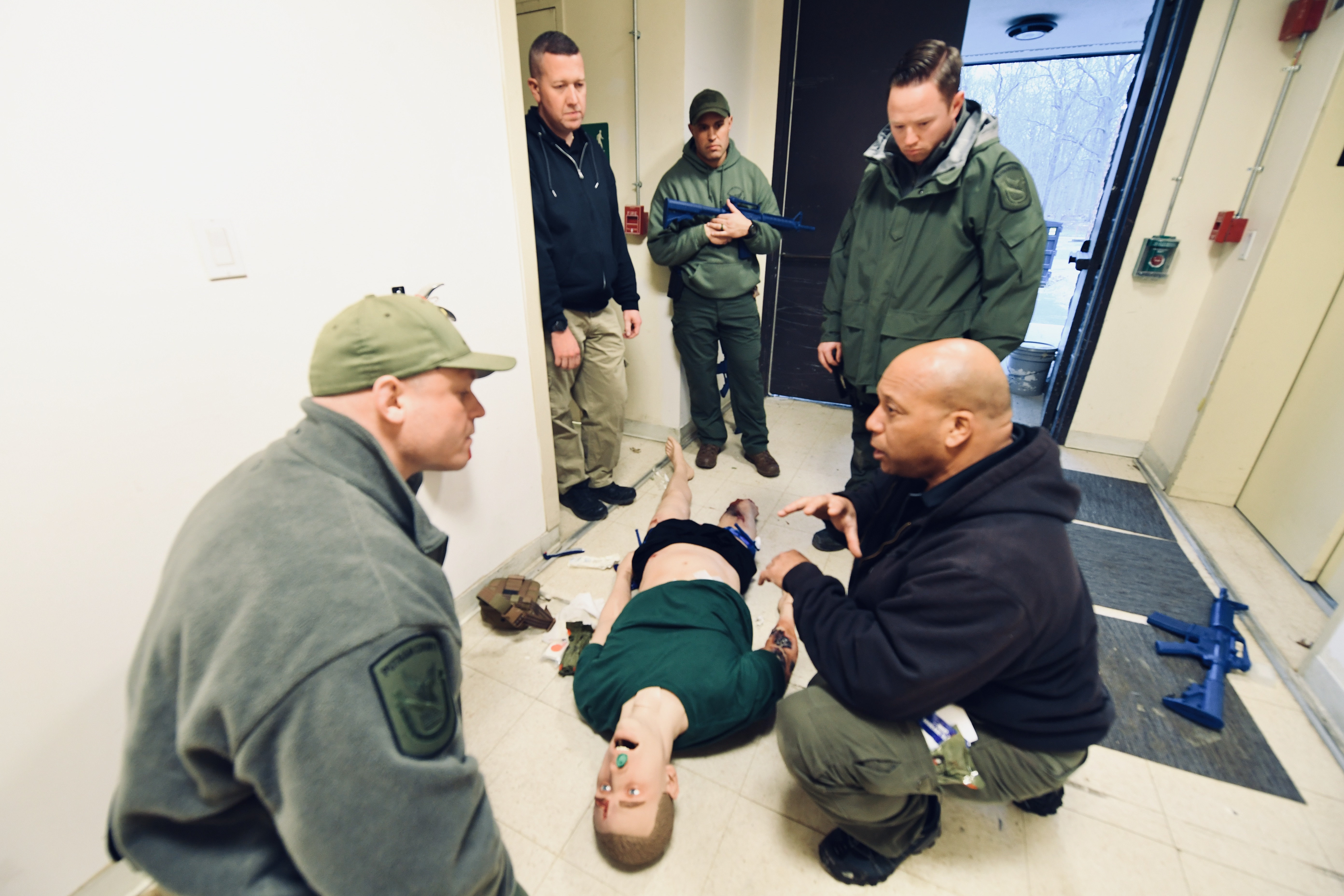 Group of people huddled over a manikin for training events 