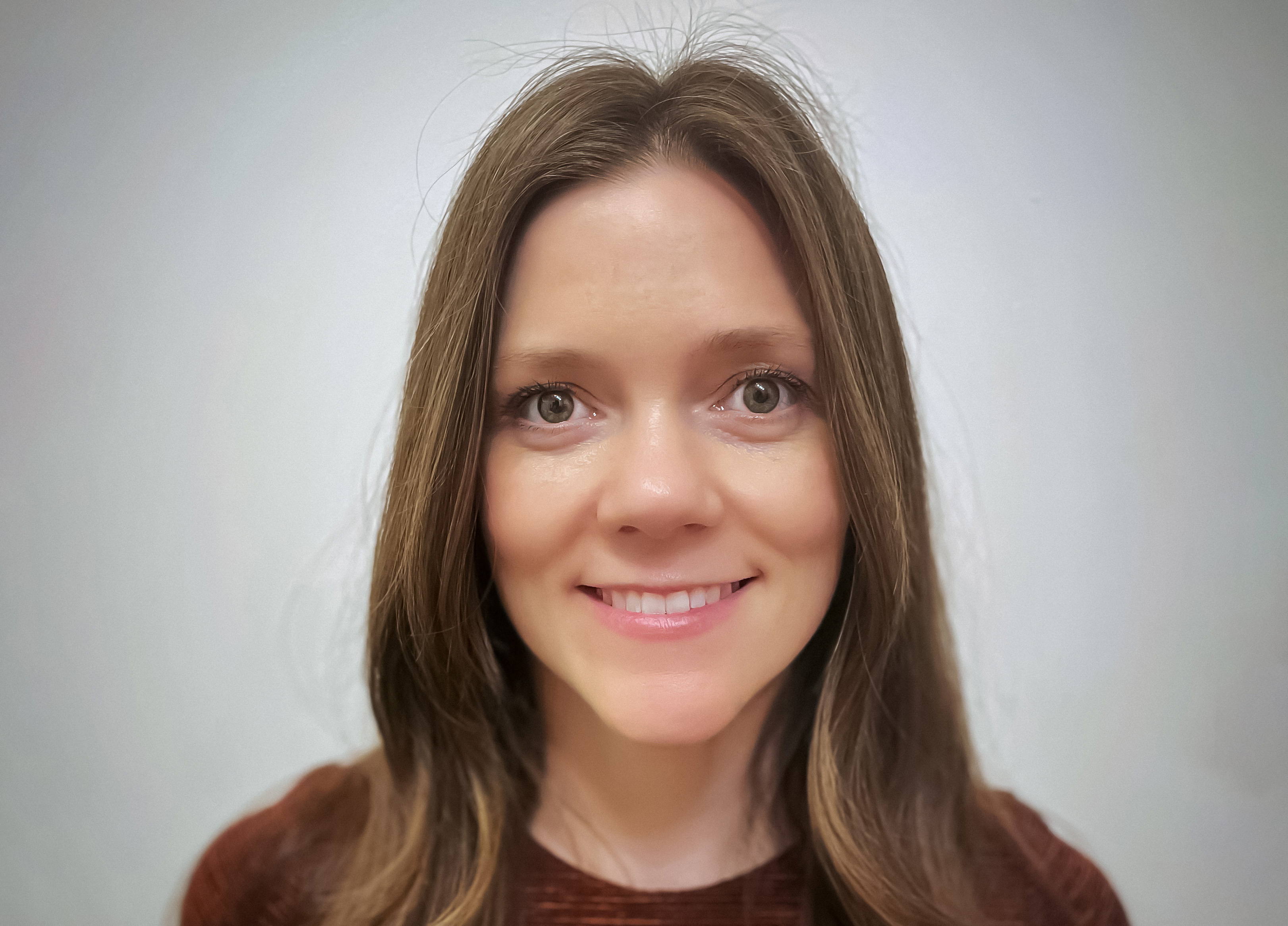 A woman with long brown hair smiling
