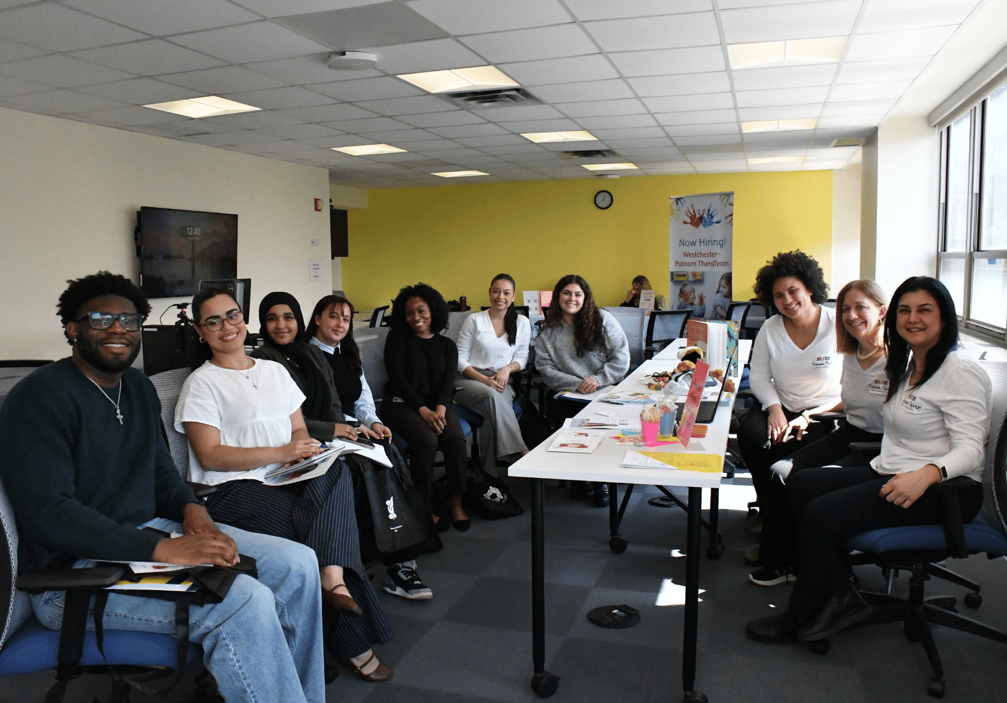 A group of students smiling while sitting in a classroom