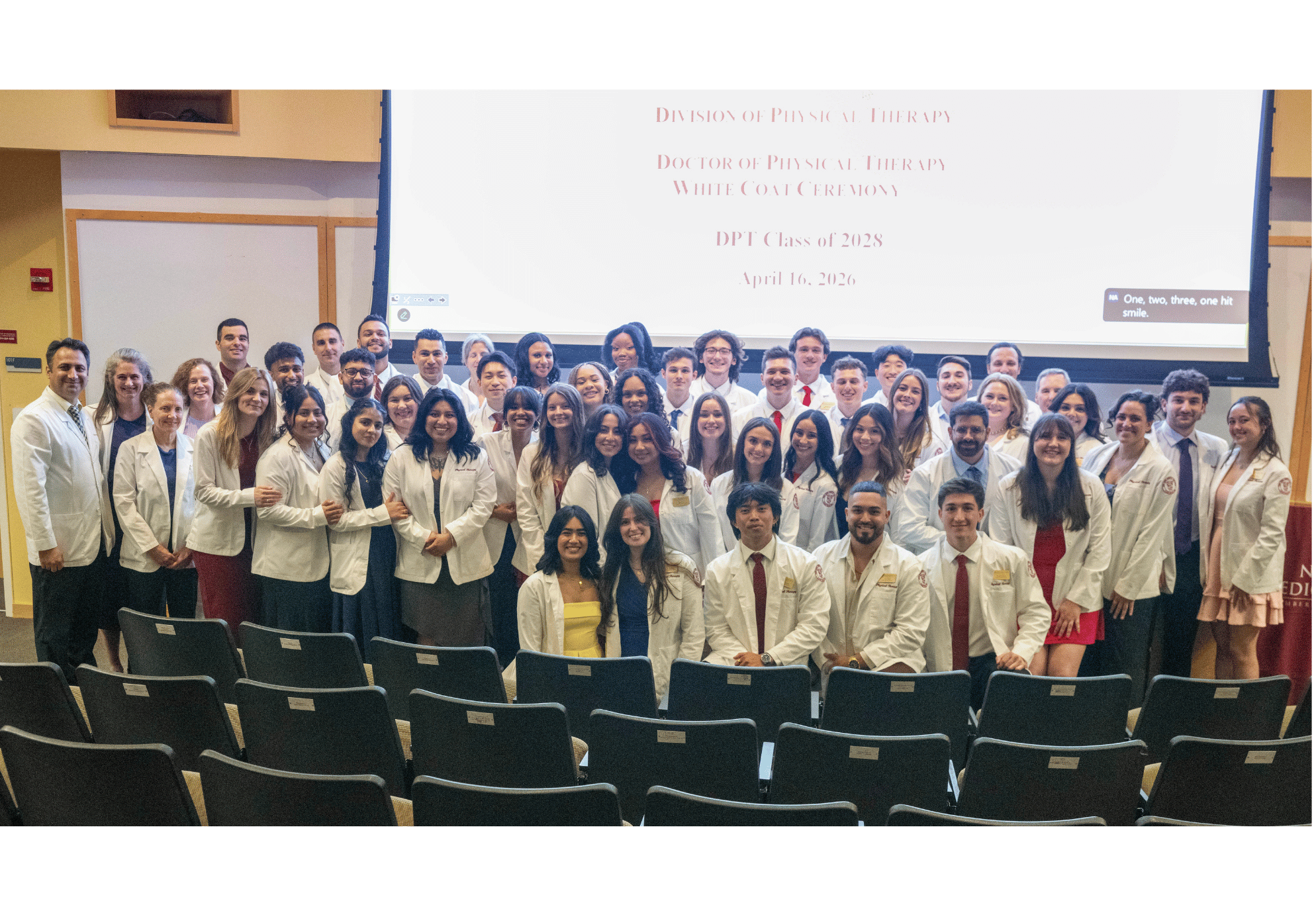 A group of physical therapy students smiling in their white coats