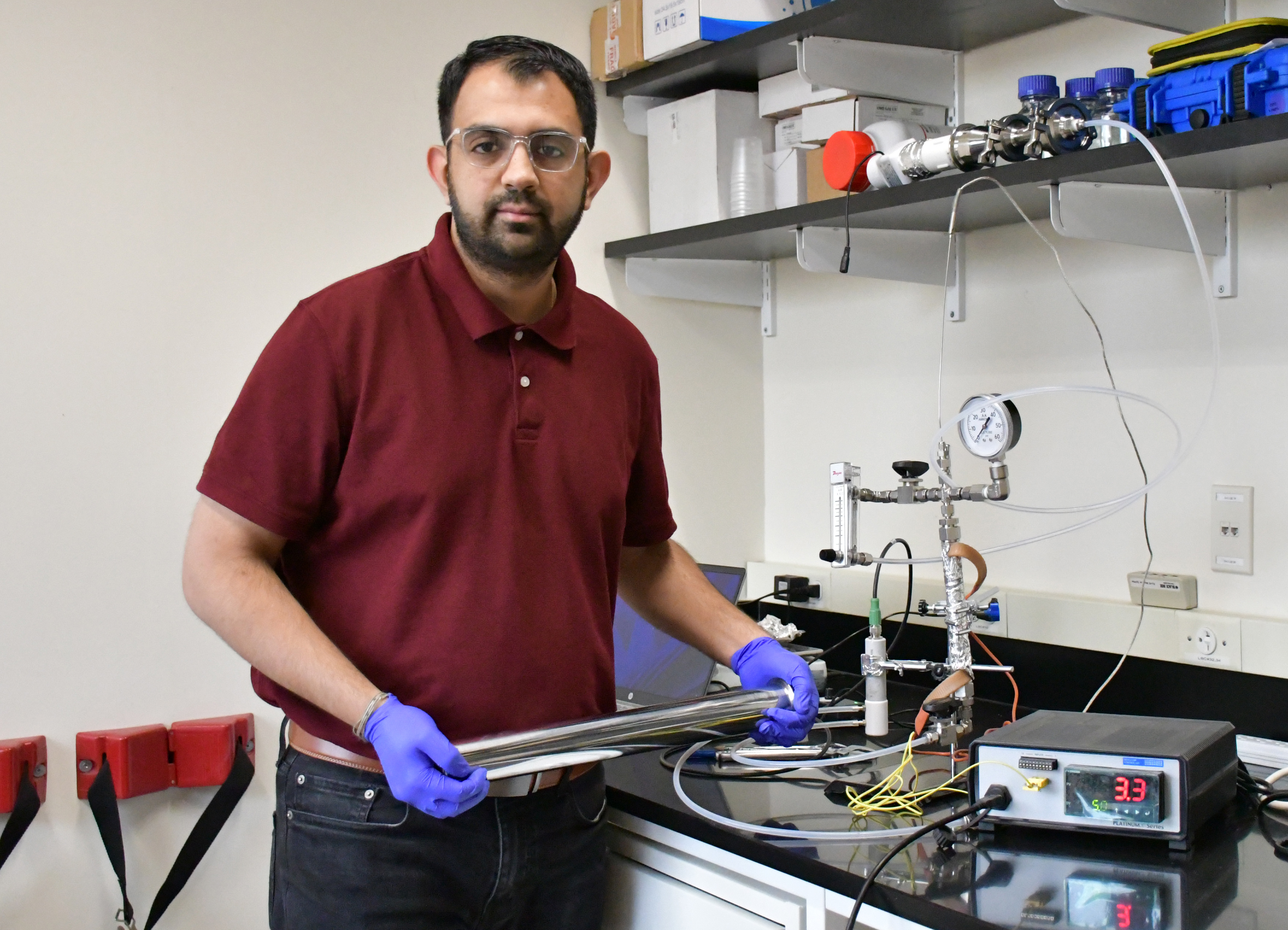 A man with a collard shirt with gloves in a lab