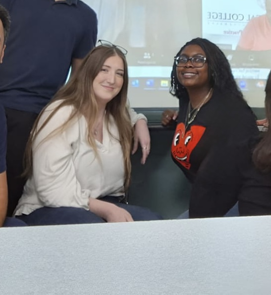 Two women smiling in front of Zoom screen
