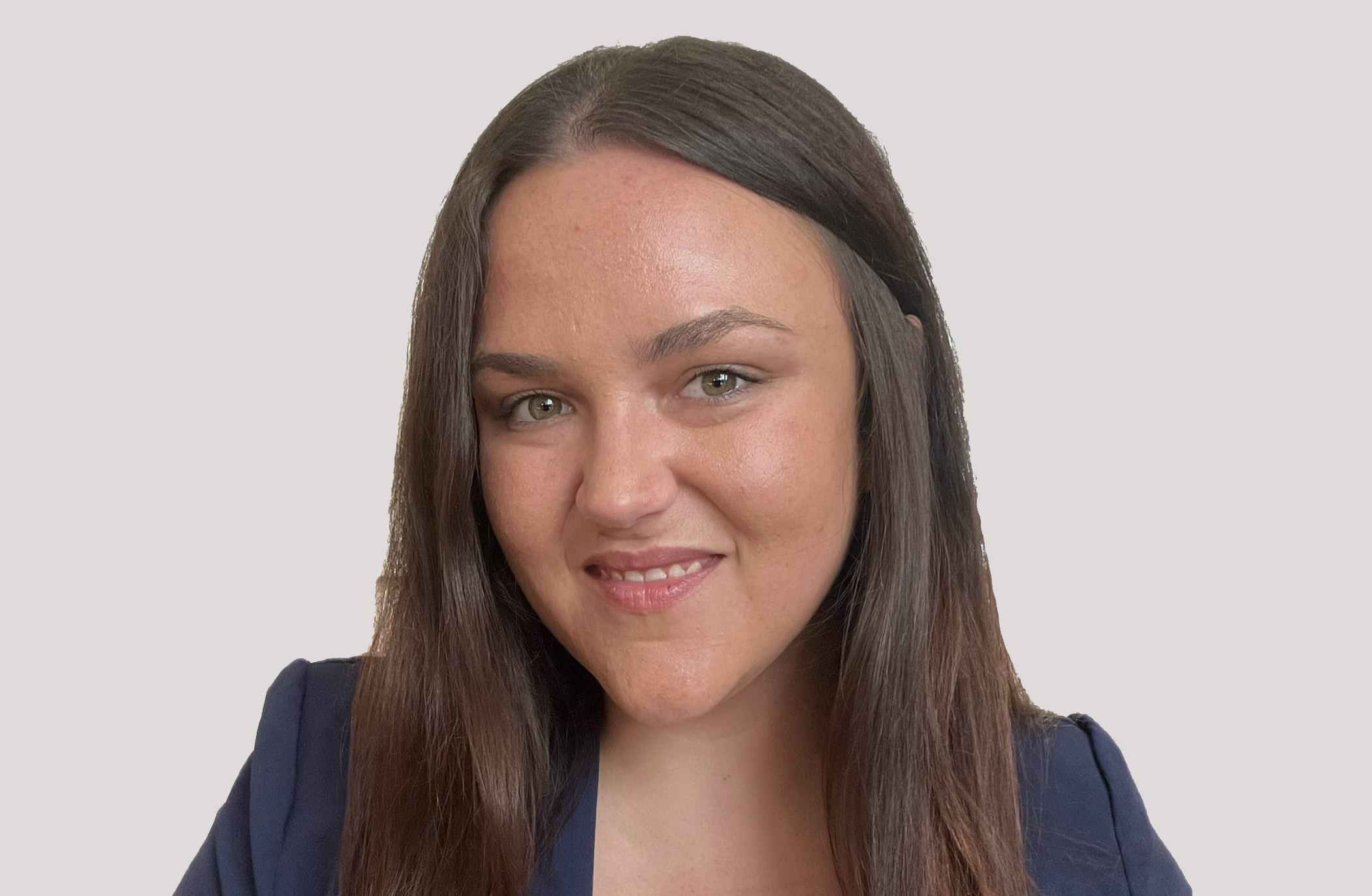 A woman with long hair smiling with a blue blazer.