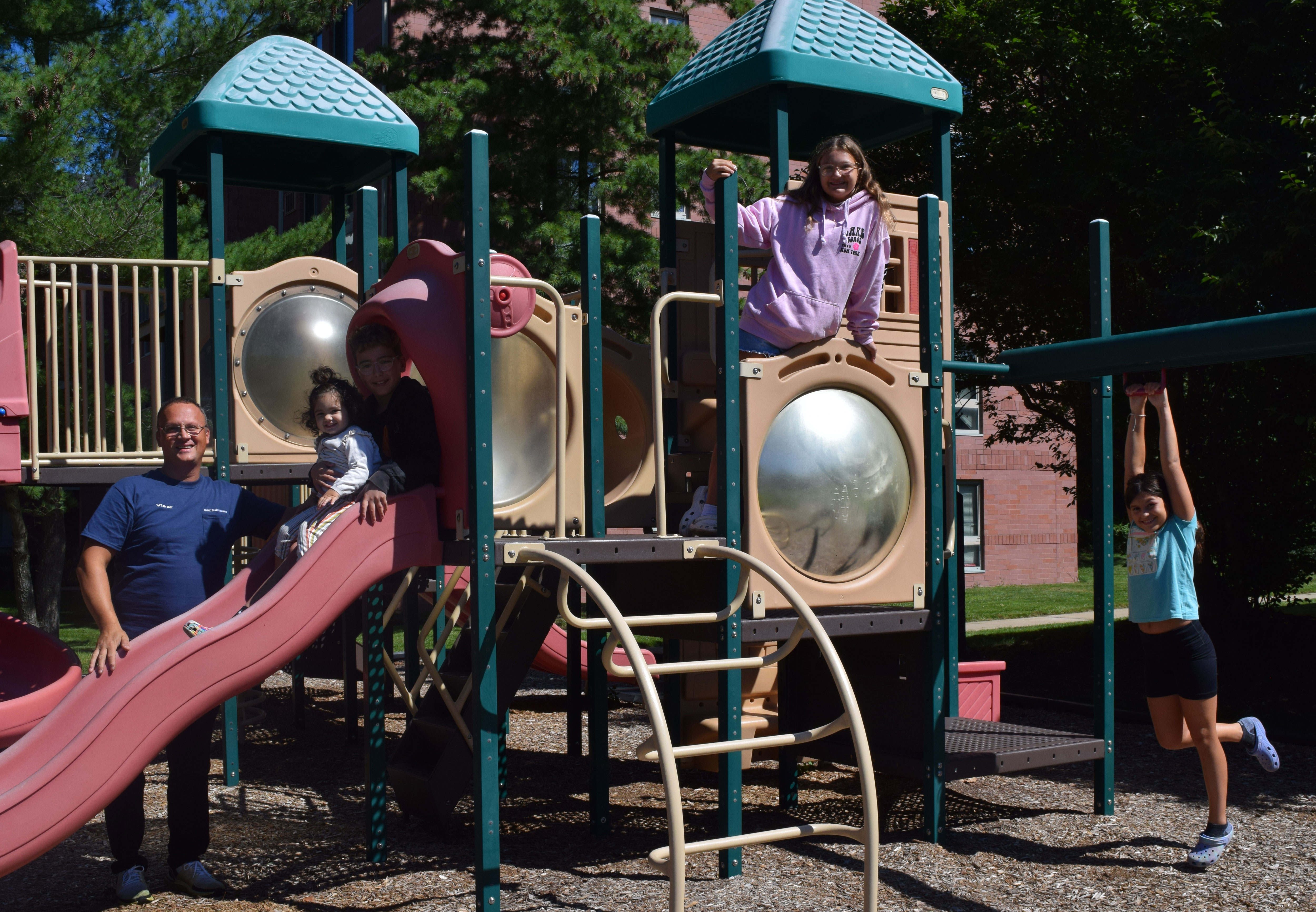 Man with children on a playground playing.