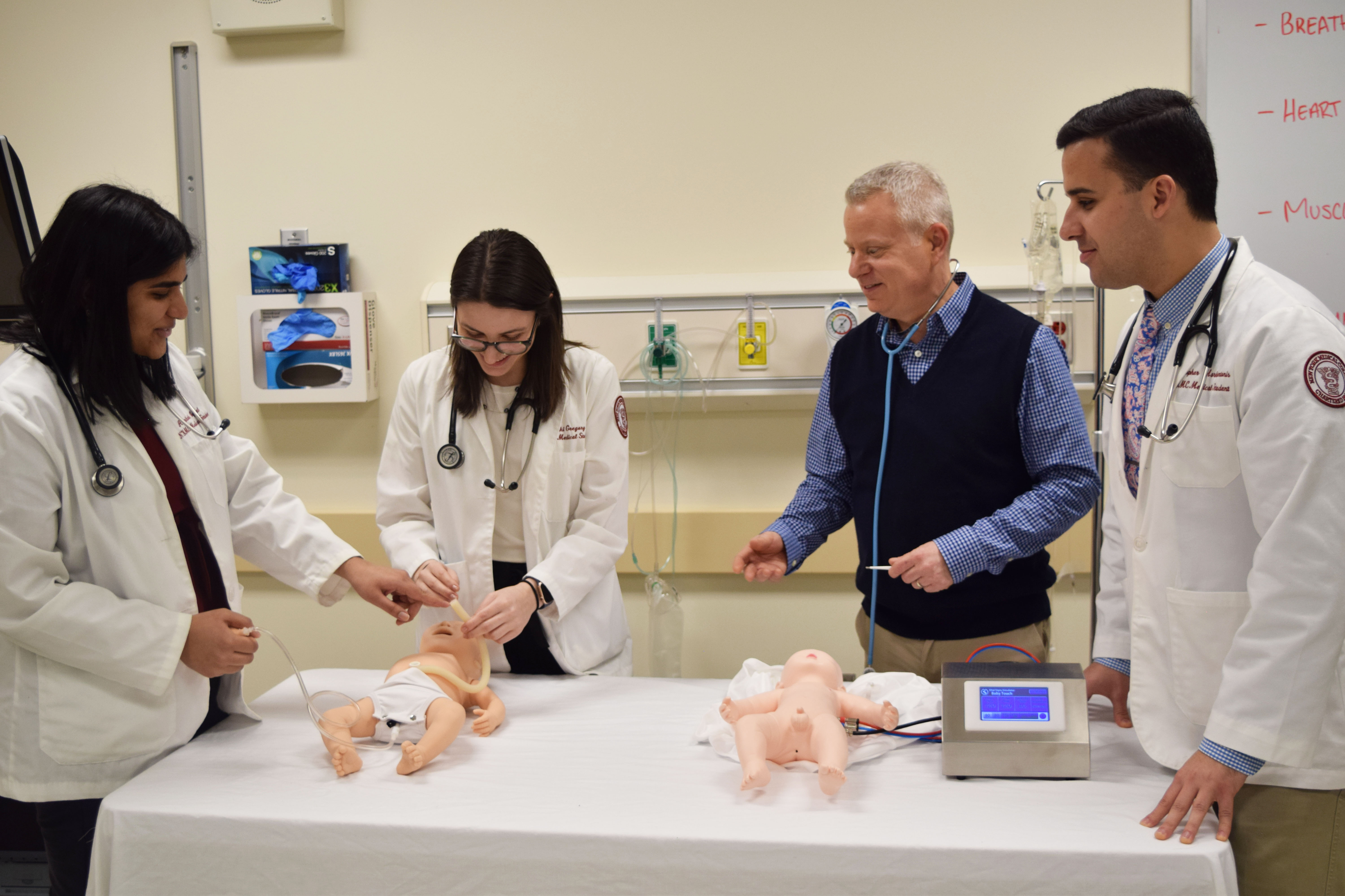 Medical students practicing on baby and head manikins