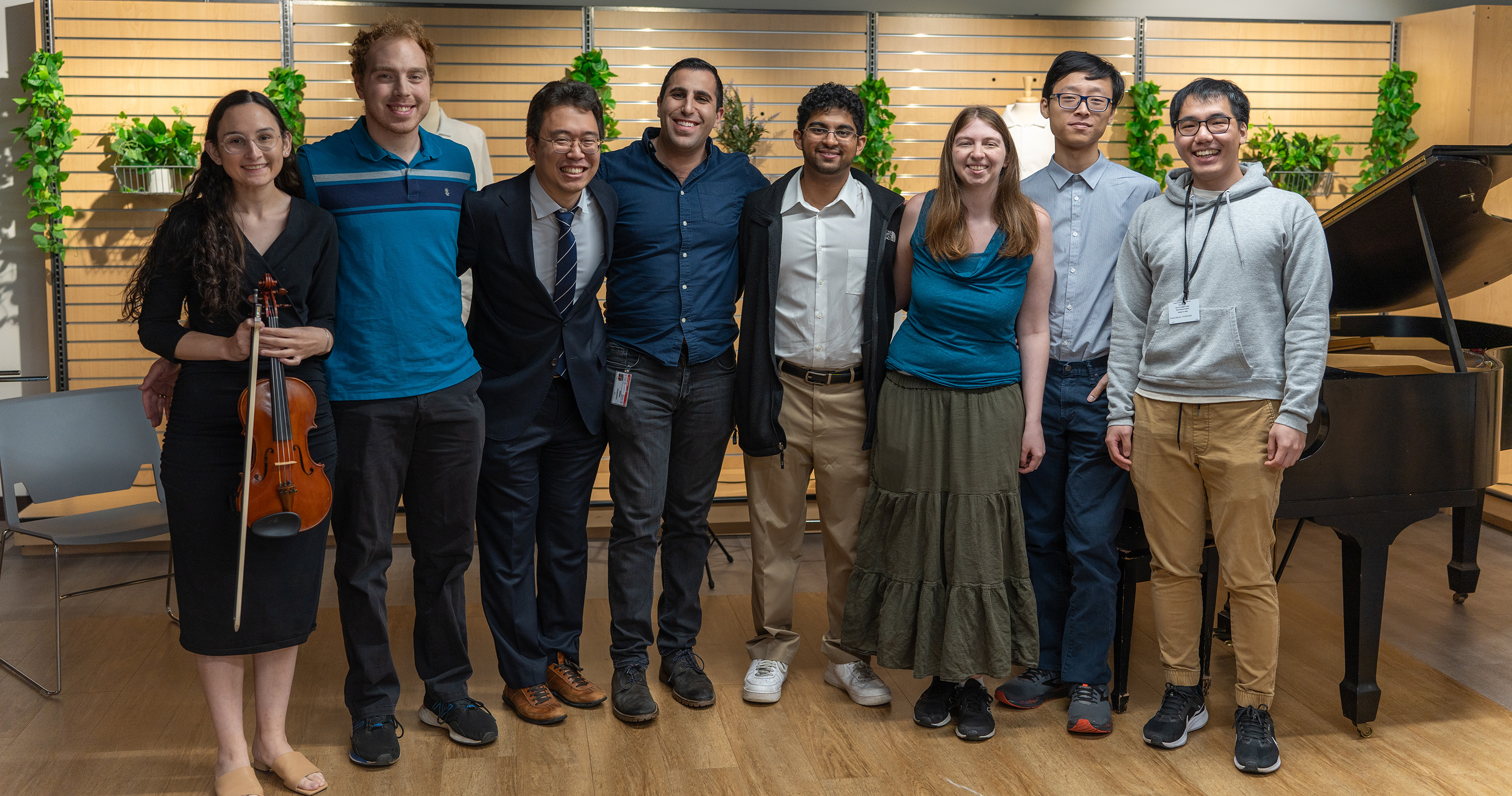 A group of students wearing formal attire in front of a piano