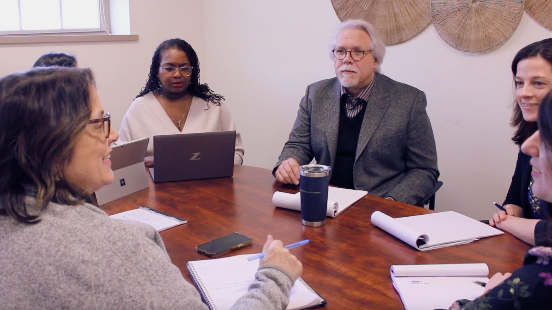 A group of professionals sitting at a conference table at a meeting.