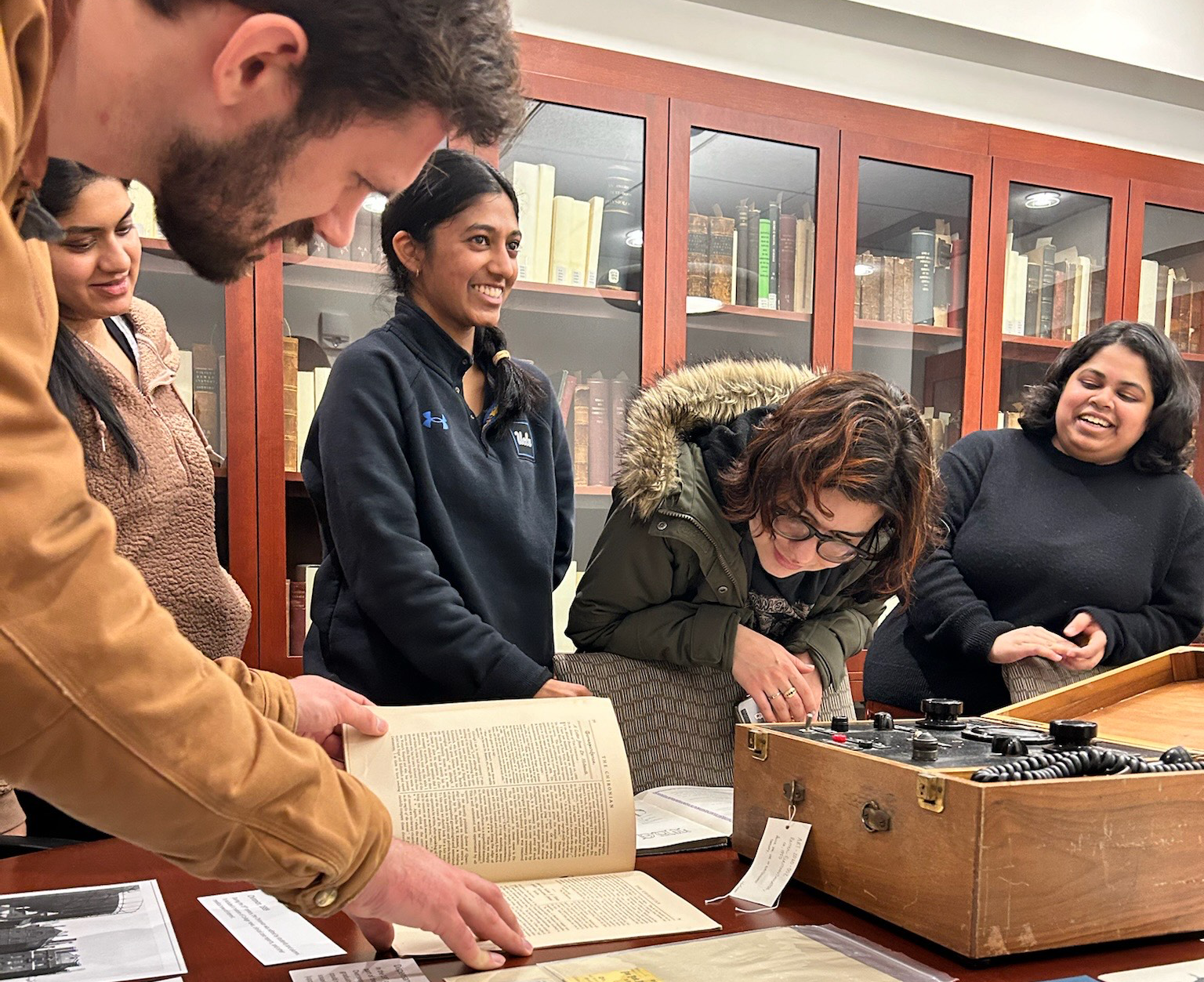 Students in conference room looking at historical artifacts.