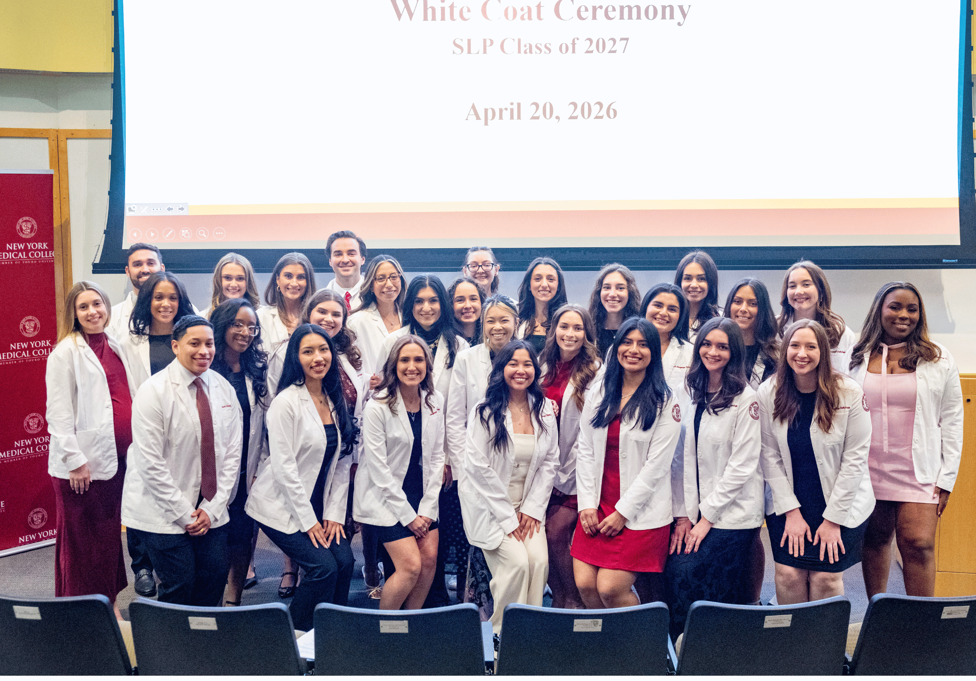 A group of speech students smiling while wearing white coats