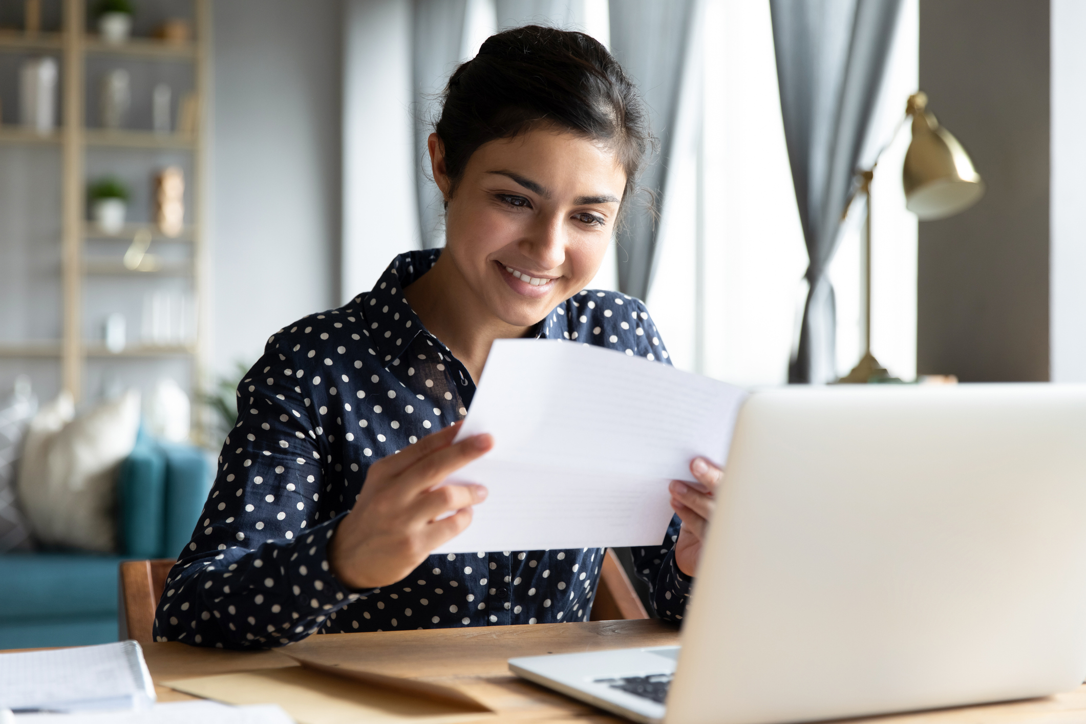 Woman reading document in front of her computer