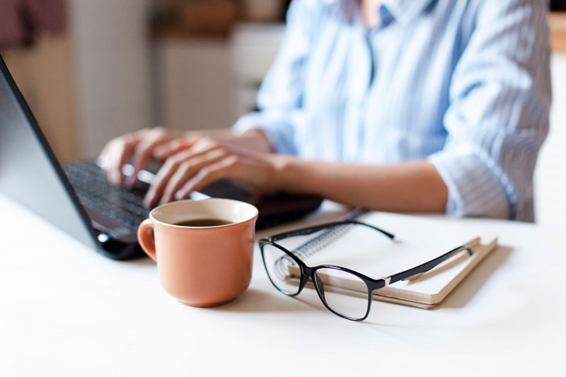 A person working remotely on a laptop at a desk