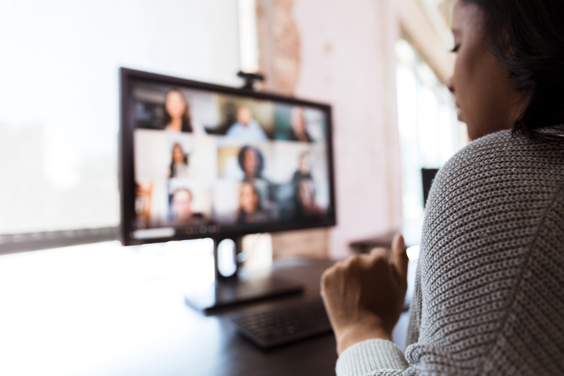 Person sitting in front of computer viewing virtual meeting