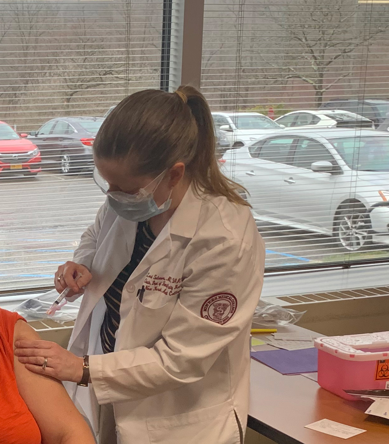 Lori Solomon, M.D. \'99, M.P.H. \'09, director of the Family Health Center, vaccinating a patient