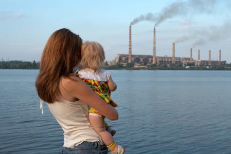 Woman with Child Looking at Smoke Stacks