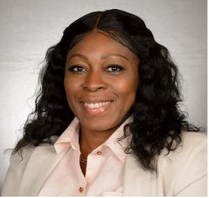 Women posing for headshot wearing light colored blazer and pink collared shirt